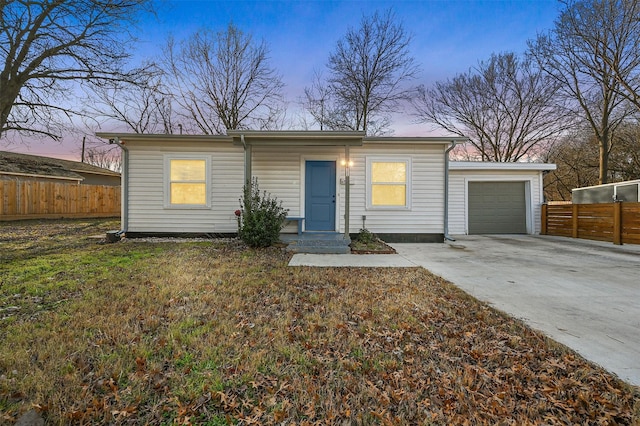 ranch-style house with a garage and a lawn