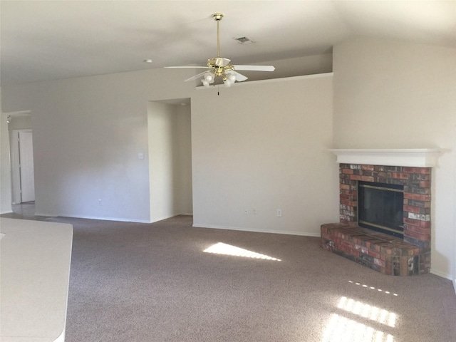 unfurnished living room with a brick fireplace, vaulted ceiling, ceiling fan, and carpet flooring