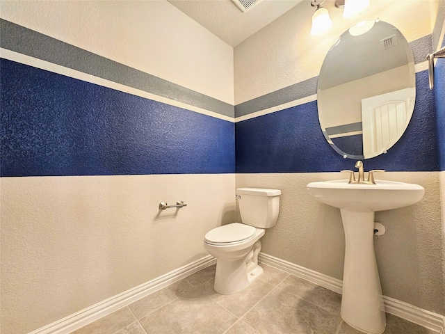 bathroom featuring lofted ceiling, a textured ceiling, tile patterned floors, and toilet