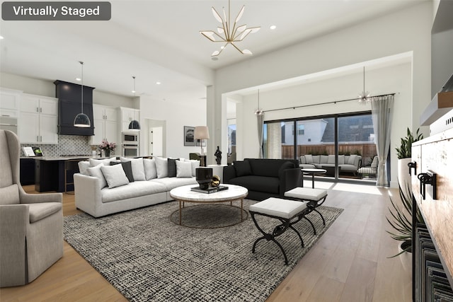 living room with an inviting chandelier and light wood-type flooring