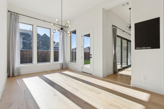 interior space with an inviting chandelier and light hardwood / wood-style floors