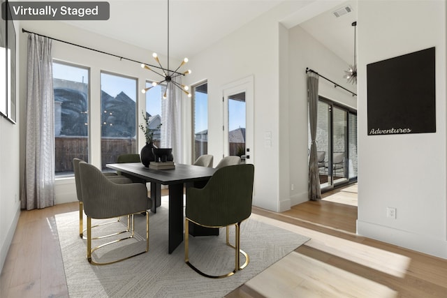 dining room with an inviting chandelier, light hardwood / wood-style floors, and a wealth of natural light