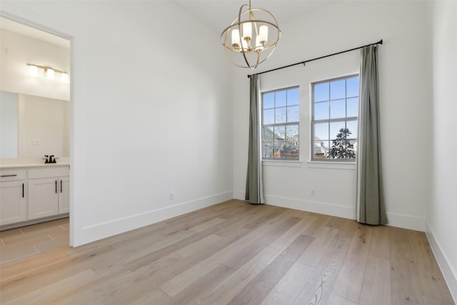 unfurnished dining area featuring sink, light hardwood / wood-style flooring, and a notable chandelier