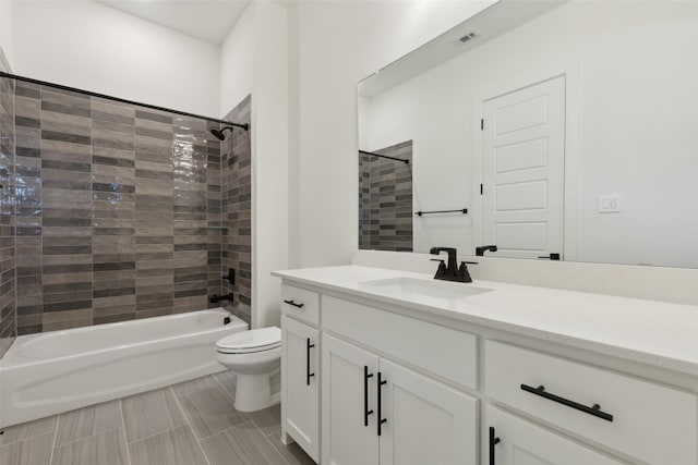 full bathroom with vanity, tiled shower / bath combo, and toilet