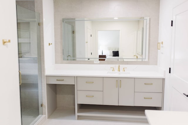 bathroom featuring a shower with door and vanity