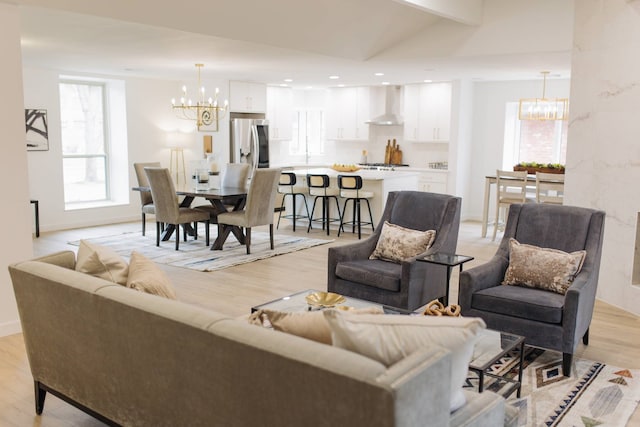 living room with an inviting chandelier and light wood-type flooring