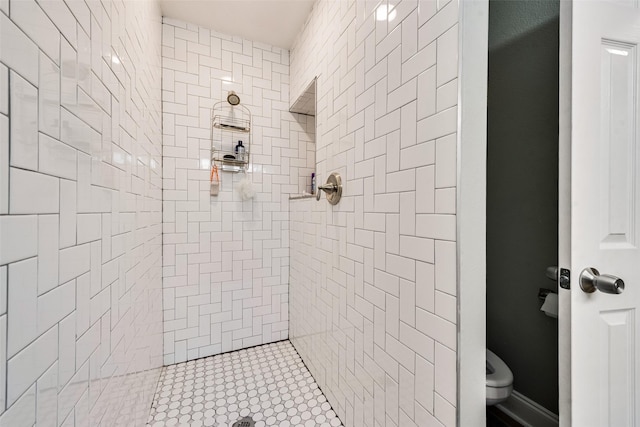 bathroom featuring tiled shower and toilet