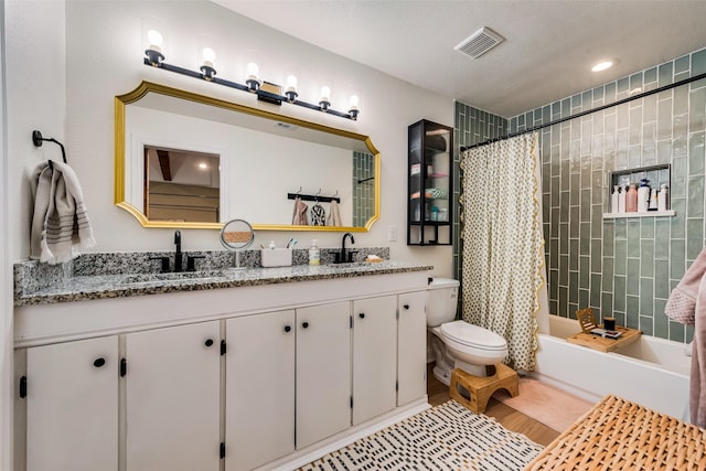 full bathroom with vanity, a textured ceiling, shower / bath combination with curtain, and toilet