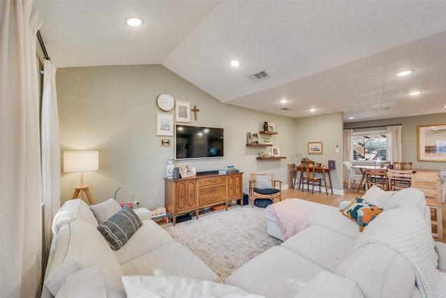 living room featuring lofted ceiling and light wood-type flooring