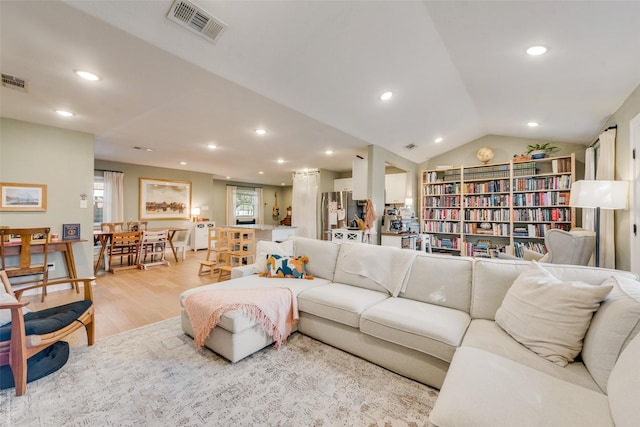 living room featuring vaulted ceiling and light hardwood / wood-style floors