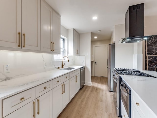 kitchen with sink, white cabinetry, stainless steel appliances, light stone countertops, and island exhaust hood