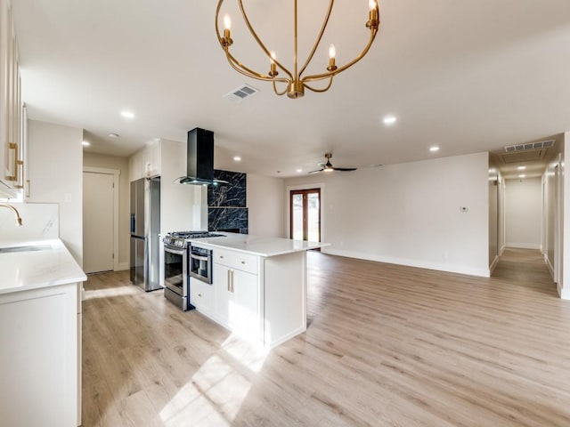 kitchen featuring stainless steel appliances, white cabinetry, light hardwood / wood-style flooring, and range hood