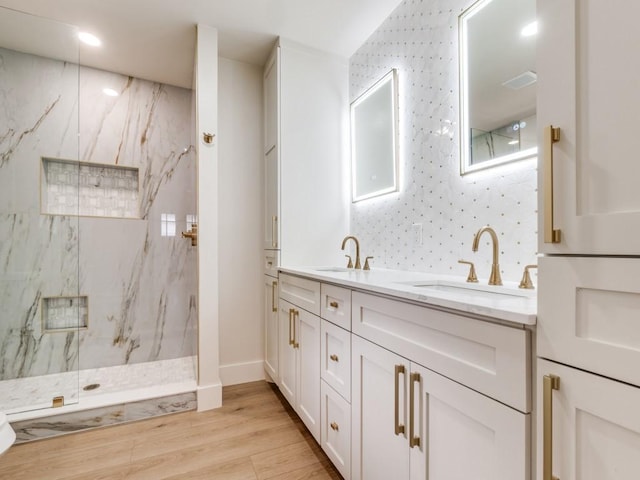 bathroom with a tile shower, hardwood / wood-style floors, and vanity