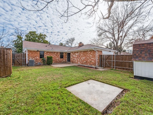 rear view of property featuring central AC unit, a yard, and a patio