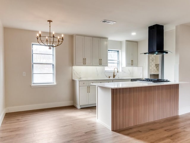 kitchen featuring pendant lighting, white cabinets, light hardwood / wood-style floors, and exhaust hood