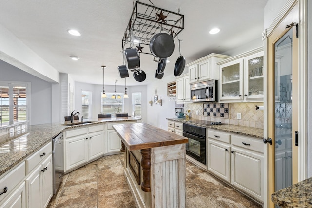 kitchen featuring sink, wooden counters, black appliances, pendant lighting, and white cabinets