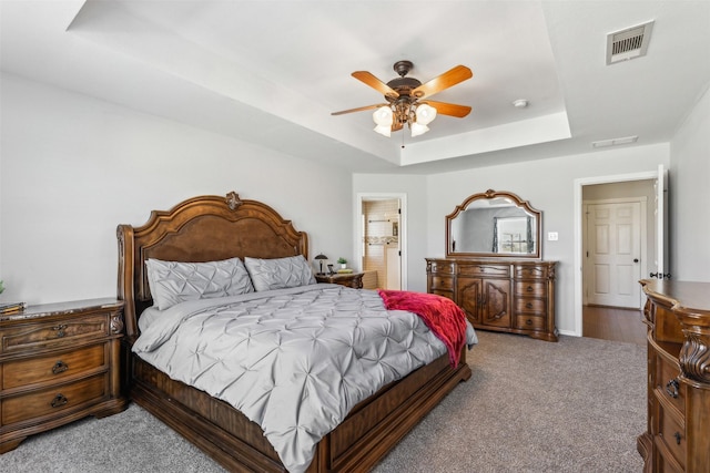 bedroom featuring a tray ceiling, ceiling fan, and carpet