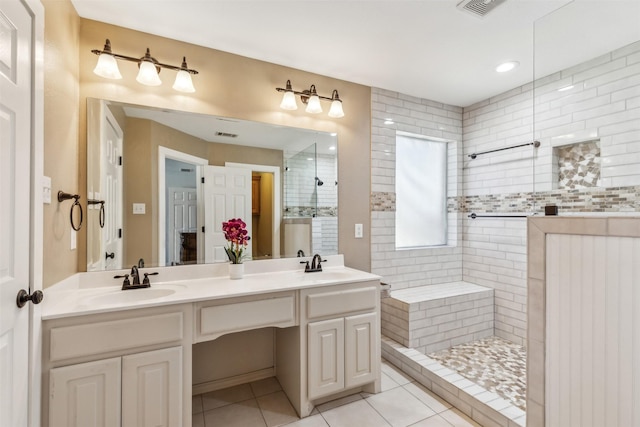 bathroom featuring tile patterned flooring, vanity, and tiled shower