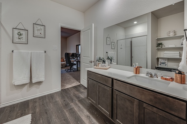 bathroom featuring hardwood / wood-style flooring, vanity, and an enclosed shower