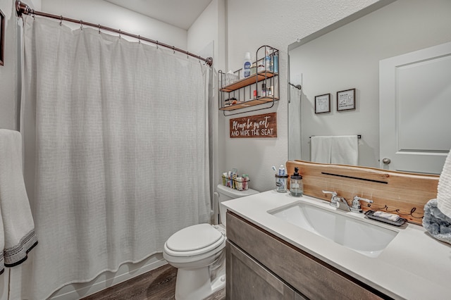 full bathroom featuring hardwood / wood-style flooring, vanity, shower / bath combination with curtain, and toilet