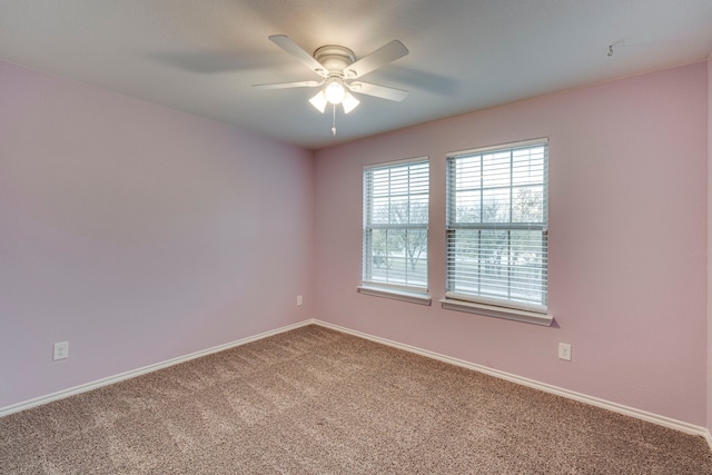 carpeted spare room featuring ceiling fan