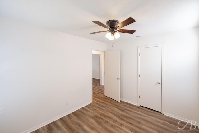 unfurnished bedroom featuring dark wood-type flooring and ceiling fan