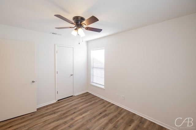 unfurnished bedroom featuring hardwood / wood-style floors, ceiling fan, and a closet