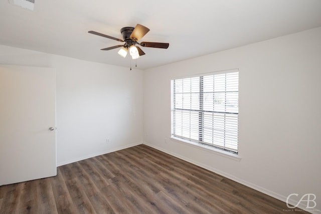 spare room featuring dark wood-type flooring and ceiling fan