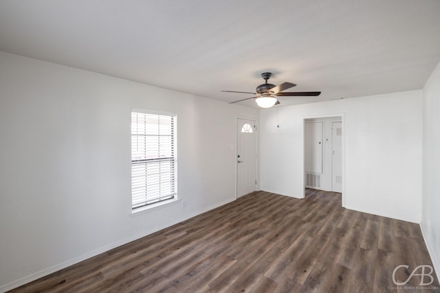 spare room featuring dark wood-type flooring and ceiling fan