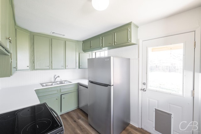 kitchen featuring sink, stainless steel fridge, electric range oven, a healthy amount of sunlight, and green cabinetry