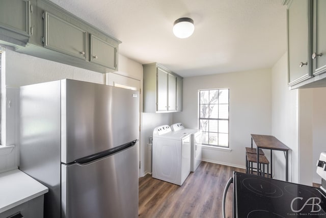 washroom with dark wood-type flooring, cabinets, and separate washer and dryer