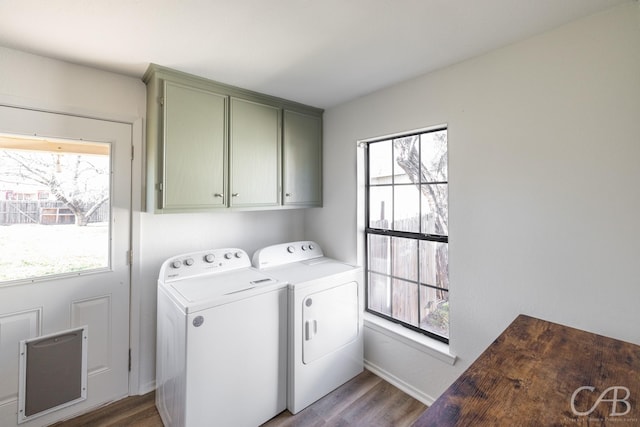 washroom featuring cabinets, independent washer and dryer, wood-type flooring, and a healthy amount of sunlight