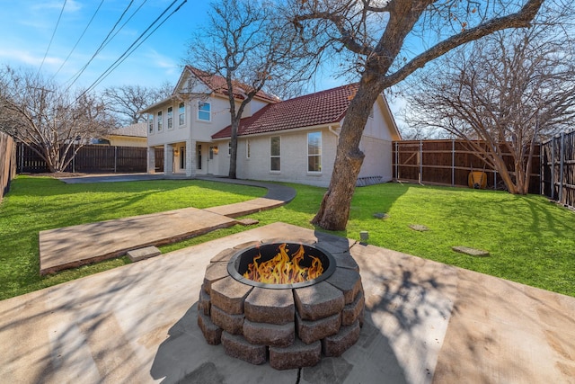 rear view of house featuring a patio, a lawn, and an outdoor fire pit