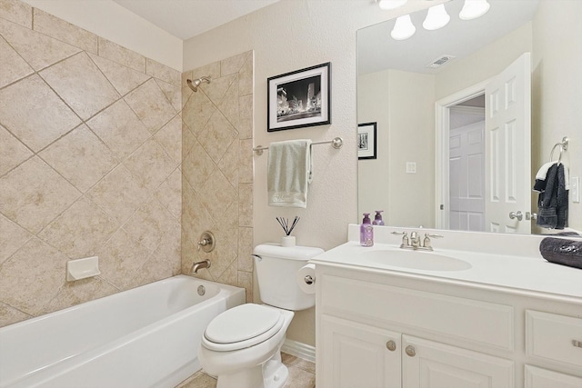 full bathroom featuring vanity, tiled shower / bath, and toilet