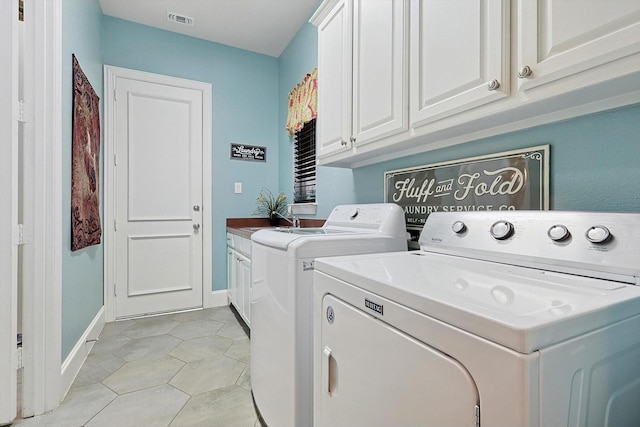 washroom with cabinets, washer and dryer, and light tile patterned floors