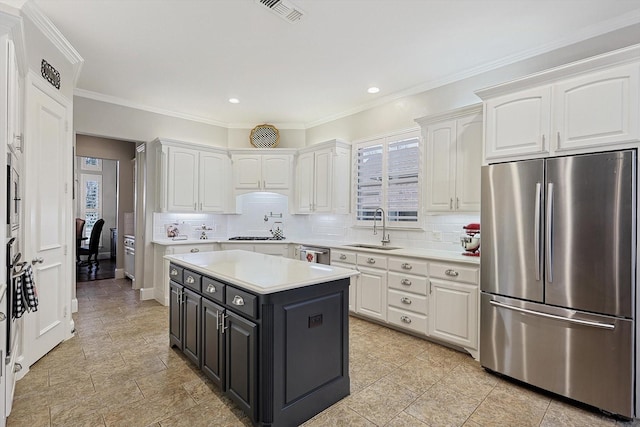 kitchen with stainless steel appliances, tasteful backsplash, sink, and white cabinets