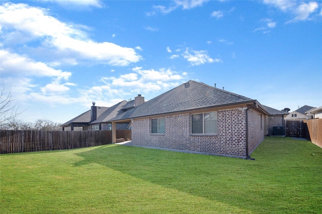 back of house featuring a yard and central air condition unit