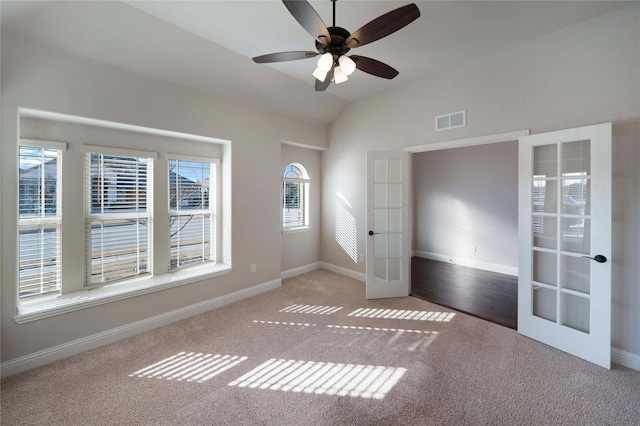 empty room with french doors, ceiling fan, lofted ceiling, and light carpet