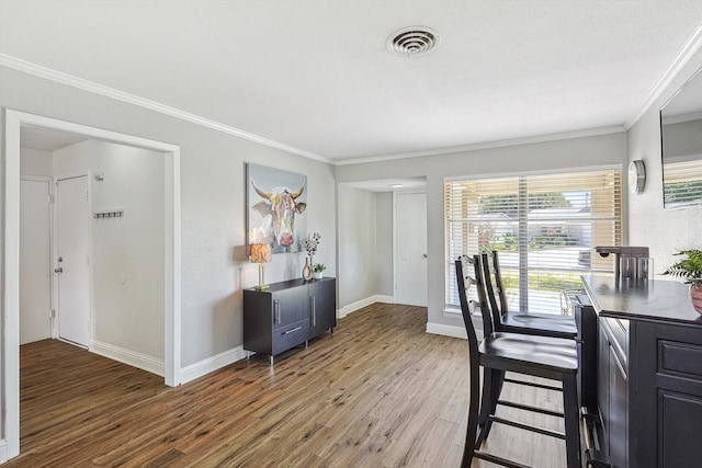 dining room with crown molding and hardwood / wood-style floors