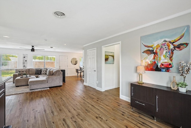 living room featuring hardwood / wood-style flooring, ornamental molding, and ceiling fan