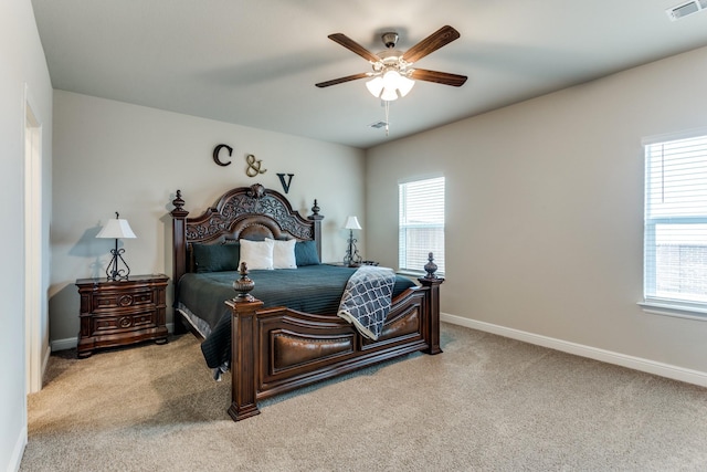 carpeted bedroom with multiple windows and ceiling fan