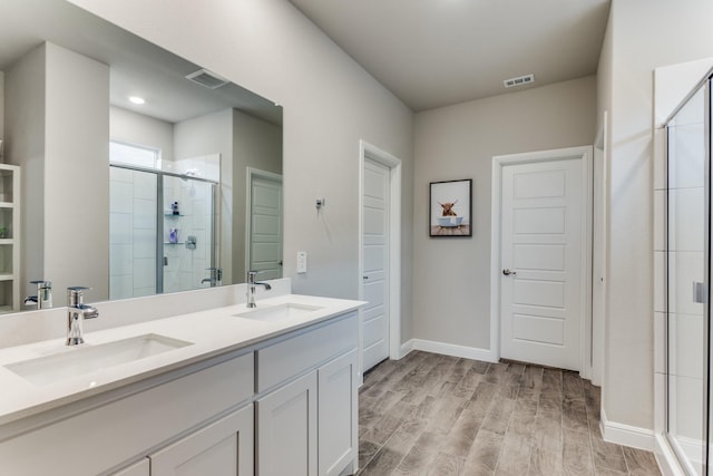 bathroom featuring vanity, hardwood / wood-style flooring, and a shower with door