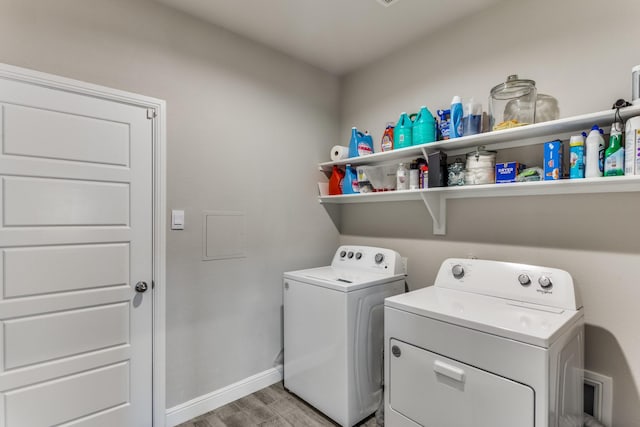 clothes washing area featuring independent washer and dryer and light hardwood / wood-style floors