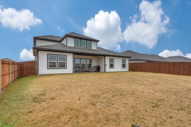 rear view of property with a lawn