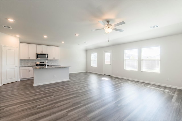 unfurnished living room featuring ceiling fan, sink, and dark hardwood / wood-style flooring