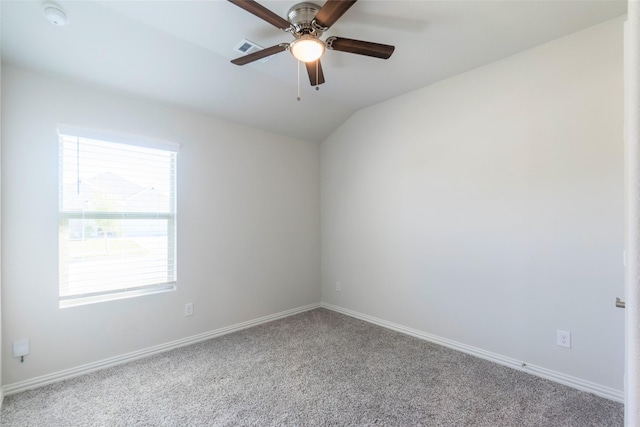 unfurnished room featuring baseboards, visible vents, lofted ceiling, ceiling fan, and carpet