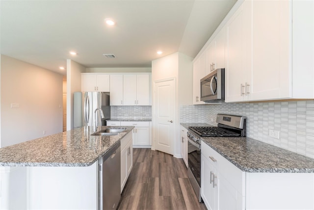 kitchen with sink, white cabinetry, a center island with sink, appliances with stainless steel finishes, and dark hardwood / wood-style flooring