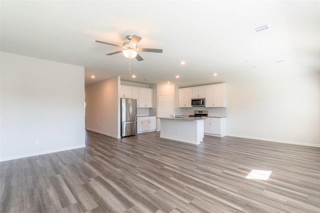 unfurnished living room with light wood-style floors, baseboards, a ceiling fan, and recessed lighting