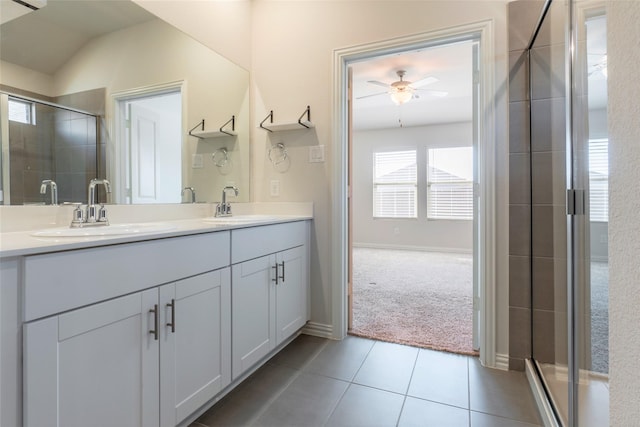 full bathroom featuring double vanity, tile patterned flooring, a sink, and a shower stall