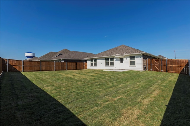 rear view of property with a yard and a patio area